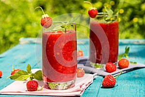 Strawberry smoothies on an old blue wooden surface