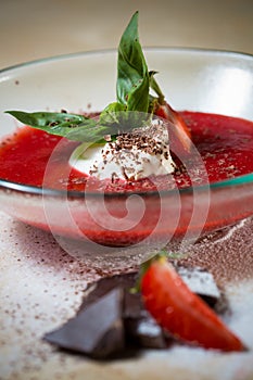 Strawberry soup with ice cream and mint on a plate