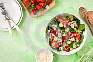 Strawberry spinach salad on a green background