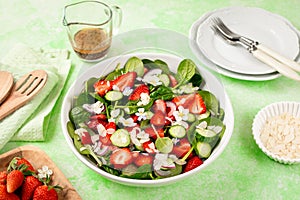 Strawberry spinach salad on a green background