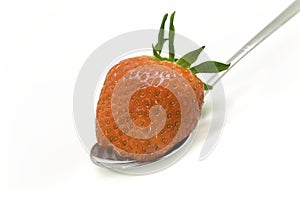 Strawberry on a spoon with a white background.