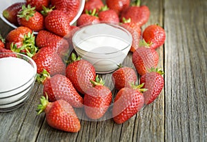 Strawberry sugar and yogurt on a wooden table.