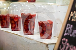 Strawberry and syrup in the plastic glass show on the shelf prepare for made to smoothies