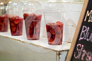 Strawberry and syrup in the plastic glass show on the shelf prepare for made to smoothies by the customer order