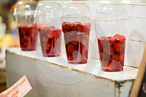 Strawberry and syrup in the plastic glass show on the shelf prepare for made to smoothies by the customer order