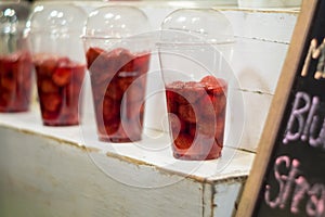 Strawberry and syrup in the plastic glass show on the shelf prepare for made to smoothies by the customer order