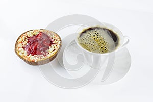 Strawberry tart with almond petals and porcelain white cup with foamy coffee and saucer on white background