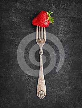 Strawberry on a vintage fork with a patina photo