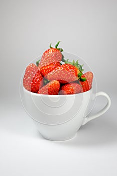 Strawberry in the white coffee cup on a white background