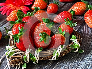 Strawberry on wooden background table top with heart-shaped wicker basket
