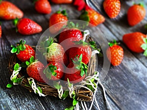 Strawberry on wooden background table top with heart-shaped wicker basket