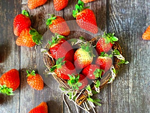 Strawberry on wooden background table top with heart-shaped wicker basket