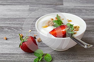 strawberry with yogurt and mint in bowl on wood