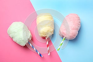 Straws with yummy cotton candy on color background