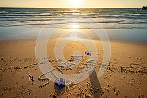 Straya text, flag and thongs on beach