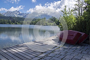 Strbske pleso, High Tatras mountains, Slovakia, early summer morning, lake reflections, red boats