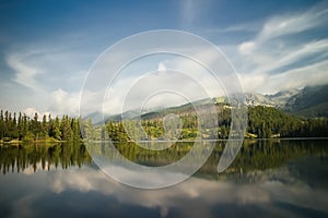 Vysoke Tatry, Strbske Pleso, Slovakia - mirroring trees on the water surface with a diving platform. Beautiful Slovakia