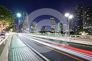 Streaking lights on Brickell key Drive with Brickell district skyline in Miami