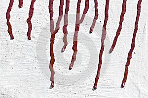 Streaks of red paint on the whitewashed wall