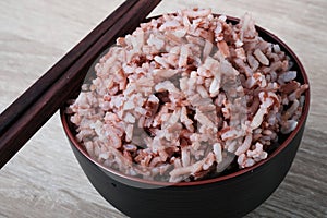 Stream brown rice in bowl and chopsticks