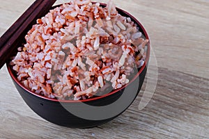 Stream brown rice in bowl and chopsticks