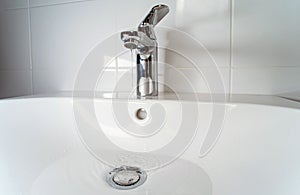 A stream of clean water flows from the mixer into the sink