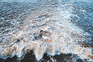 Stream of dirty meltwater on sunny spring day