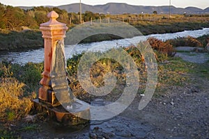 Stream of drinking water coming out of a public fountain. Video shot made in the warm light of sunset