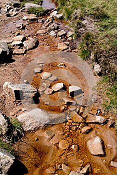 Stream, fast flowing, running down hillside in Peak District, Derbyshire, United Kingdom.