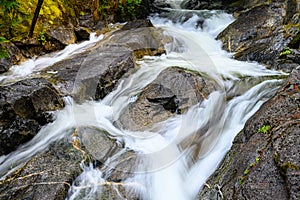 A stream flowing in many directions over rocks to find its way forward