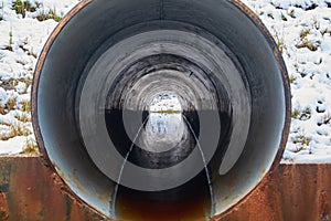 Stream in the pipe under the road