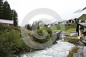 Stream and Glacier from Alps highest and most extensive mountain range flowing passed at Villages