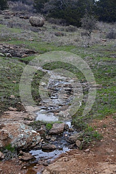 Stream with grass land of Charon's Garden trail in Wichita Mountains with greenery trees in Oklahoma photo