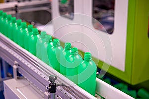 Stream of Green Plastic Bottles on Industrial Production Line. Automated Bottle Manufacturing in Progress. The Conveyor