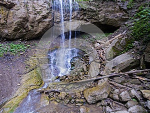 Stream mountain waterfall cascading from the cliff. Aerial view.