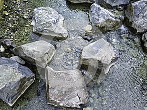 Stream in a natural area in Upper Bavaria with barrages and large stones at sunrise