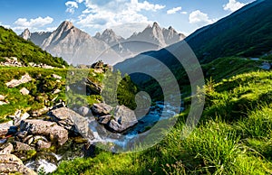 Stream among the rocks in grassy valley photo