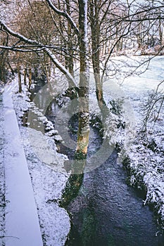 Stream surrounded by trees and roads covered in snow during storm Emma.