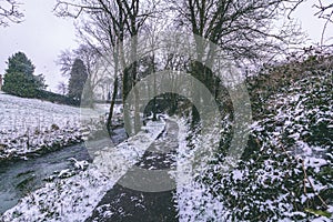 Stream surrounded by trees and roads covered in snow during storm Emma.