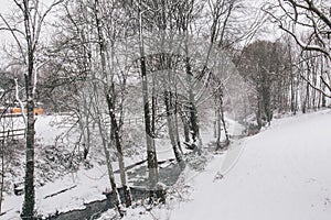 Stream surrounded by trees and roads covered in snow during storm Emma.