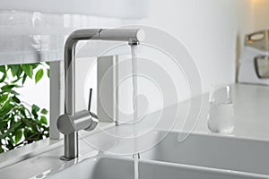 Stream of water flowing from tap in kitchen