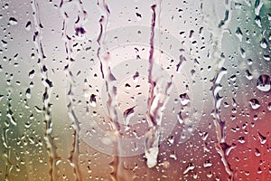 Stream of water in heavy rain. Raindrops on window pane.