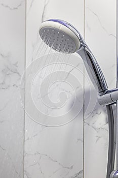 Stream of water splashing out of shower in modern bathroom. Jets of clean water flowing from shower head