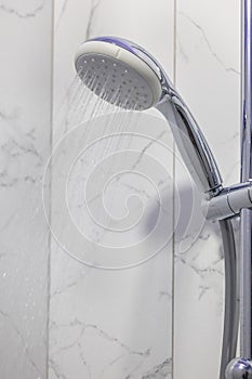 Stream of water splashing out of shower in modern bathroom. Jets of clean water flowing from shower head