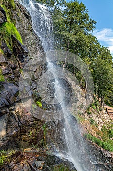 A stream of a waterfall flowing down a steep stone wall