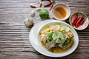 Streamed chicken meat with Thai lemon sauce served on white plate on wooden table,look tasty and delicious.