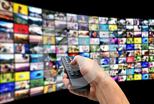 Streaming video services. Man using remote control to change channels on TV