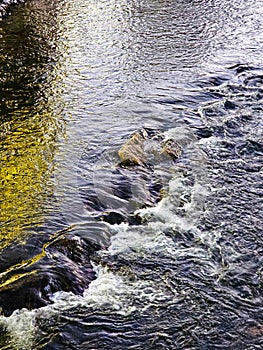 Streaming water in a small river, close-up of photo.
