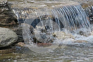 Streaming water in a small river, close-up of photo