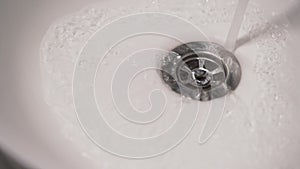 Streaming water in white sink.